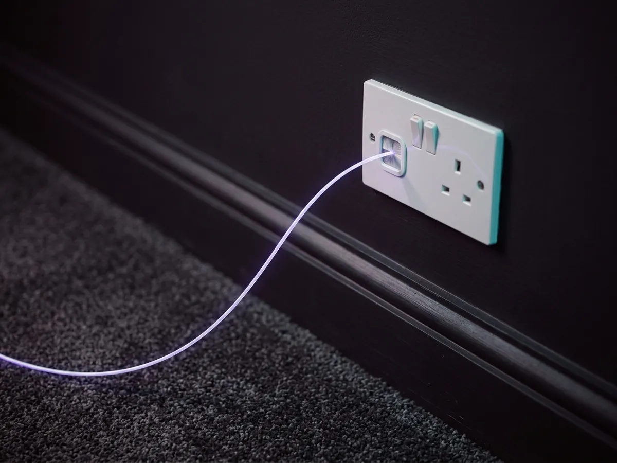 A broadband cable glowing at a wall plate