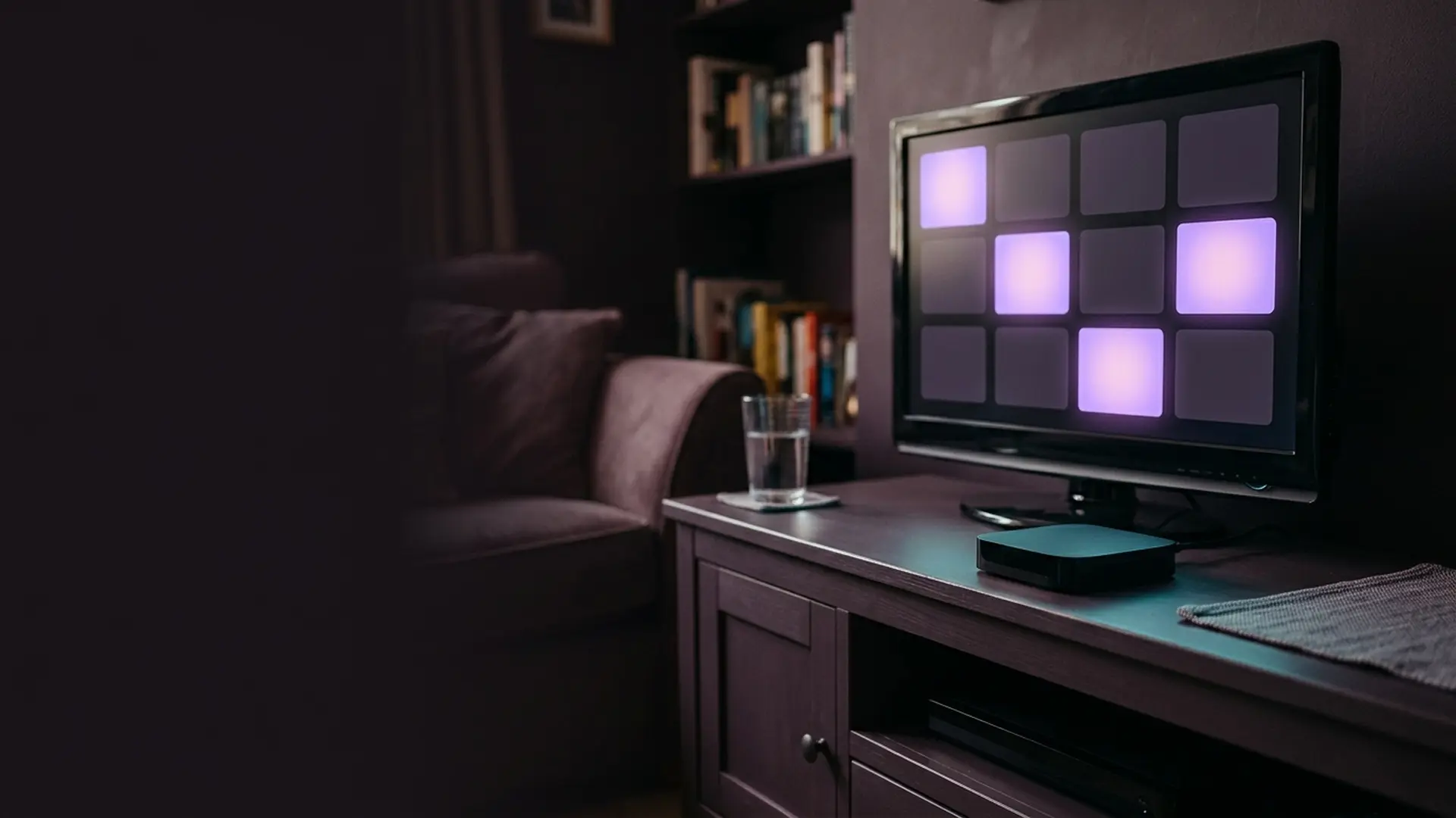 A compact streaming box under a television showing app tiles